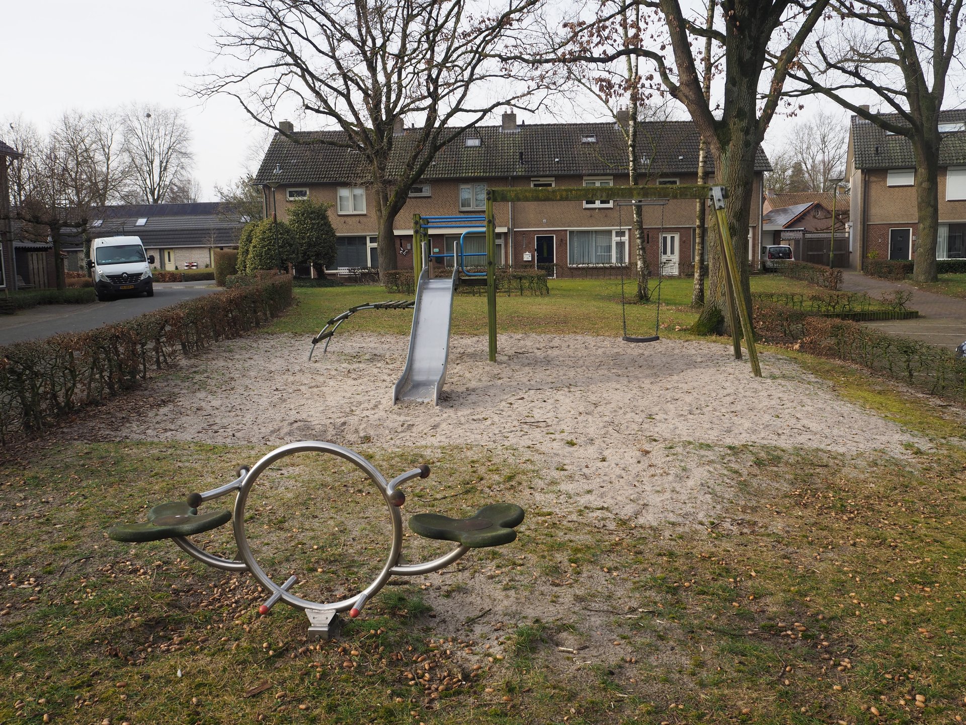 Vergroot afbeelding: vooraan een kleine wipwap met daarachter een klimrek met glijbaan en schommel. Op de achtergrond staan woningen.