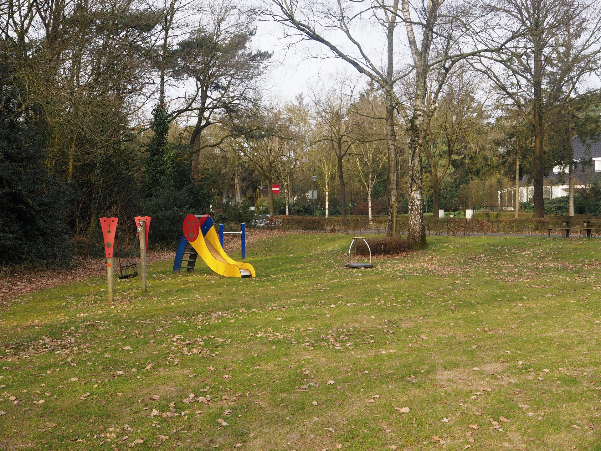 Vergroot afbeelding: aan de linkerkant speeltoestel met rechts daarvan een glijbaan. Op de achtergrond staan bomen.
