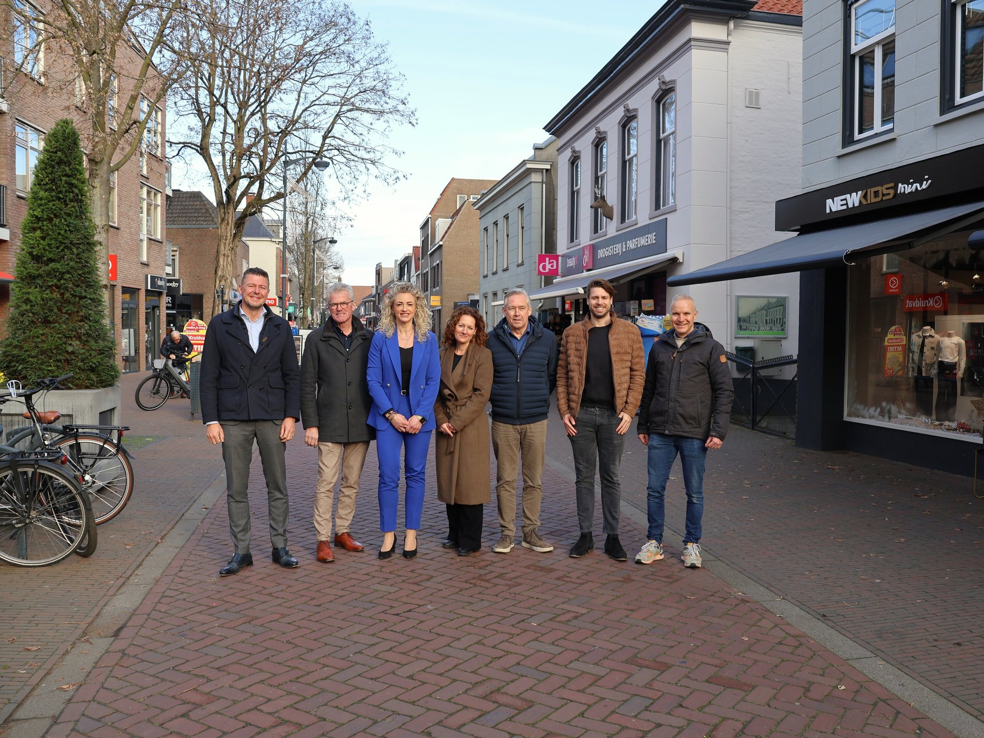 Vergroot afbeelding: wethouder Martien Bankers en wethouder Hanneke Coppens op de foto met ondernemers en centrummanager Gemert. Ze staan in de winkelstraat. Op de achtergrond staan winkelpanden.
