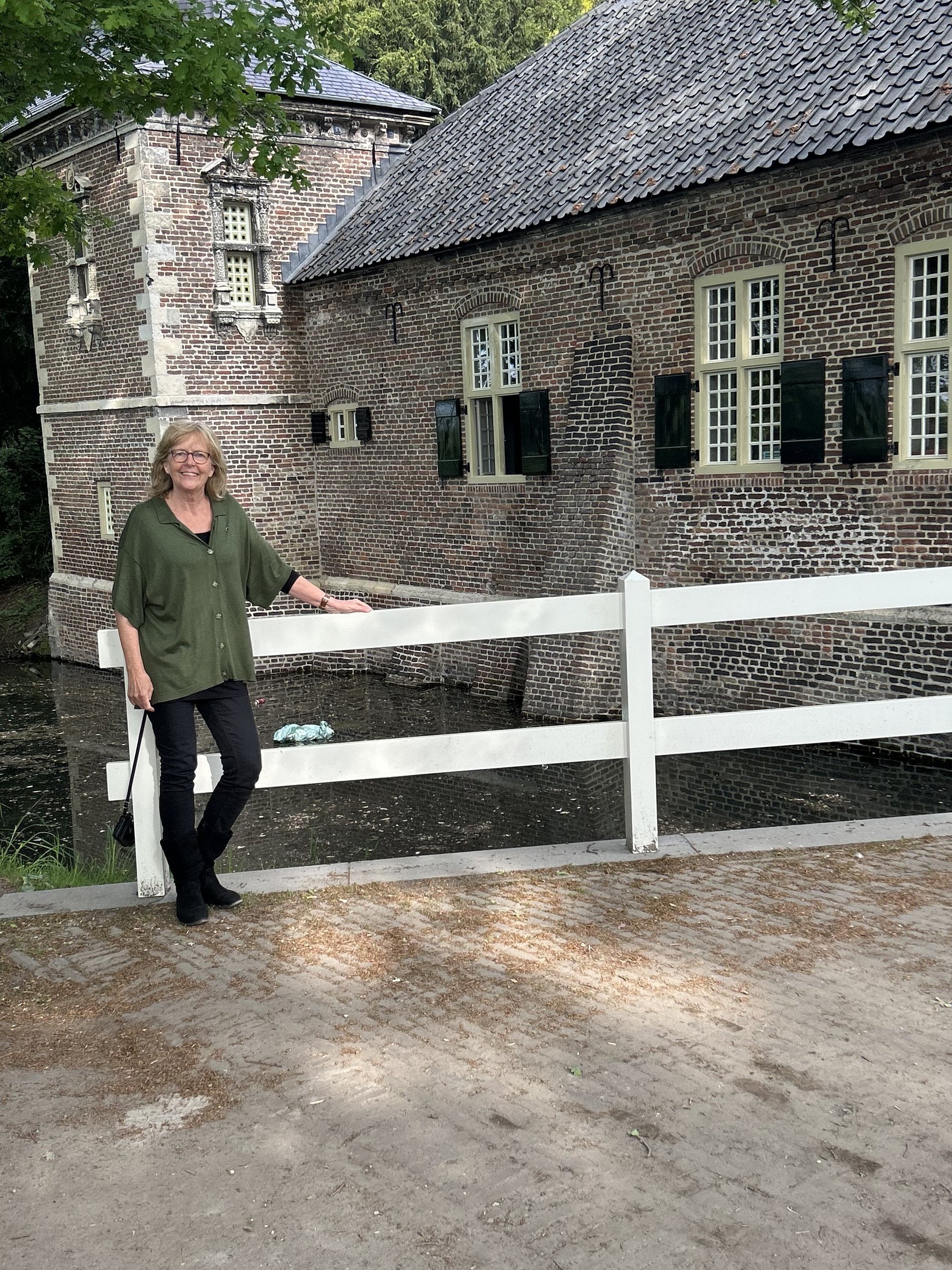 Vergroot afbeelding: Raadslid Mariëtte van Erp op de brug bij het kasteel in Gemert