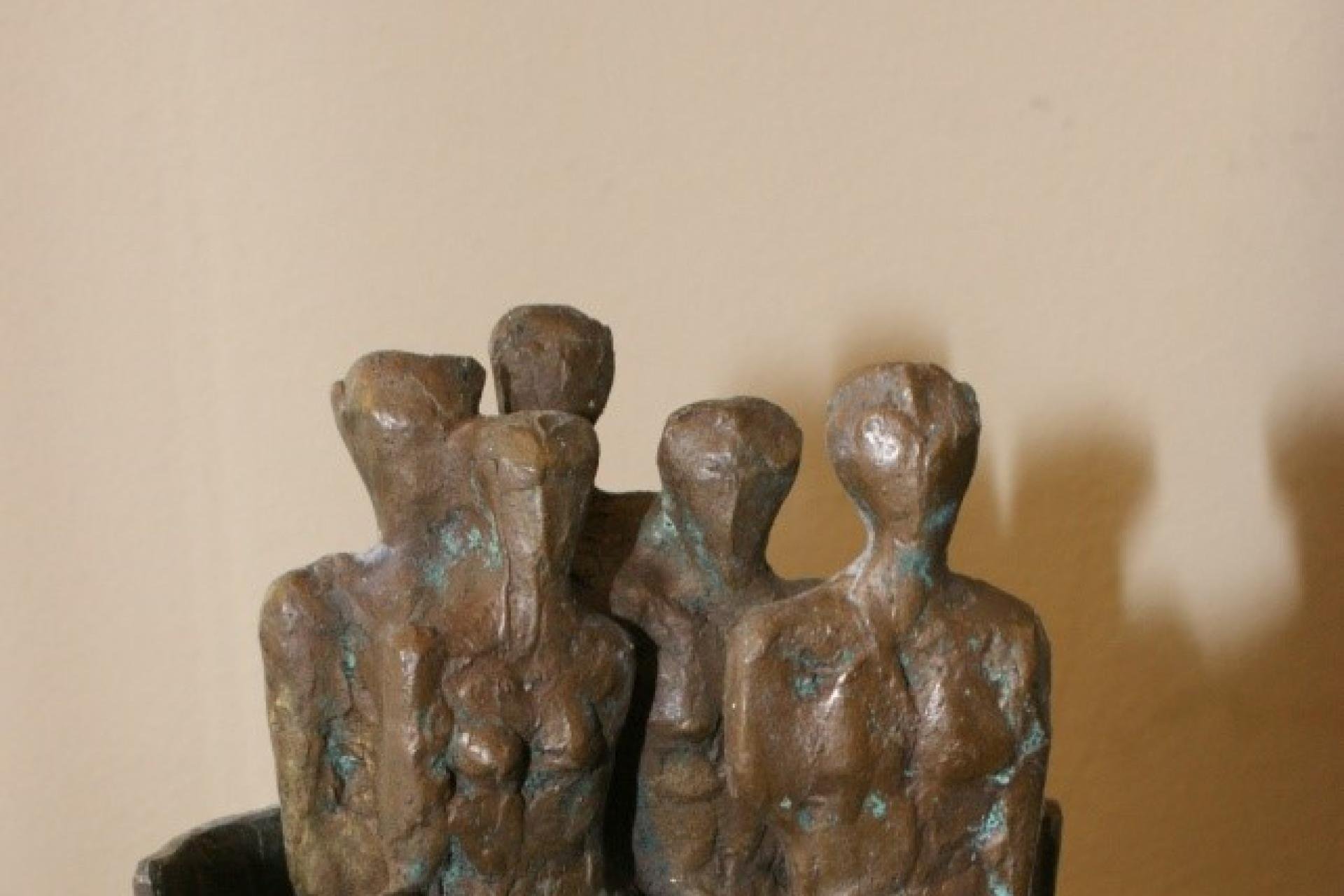 bronzen beeldje dat een groep van mensen voorstelt waarin één persoon naar voren staat